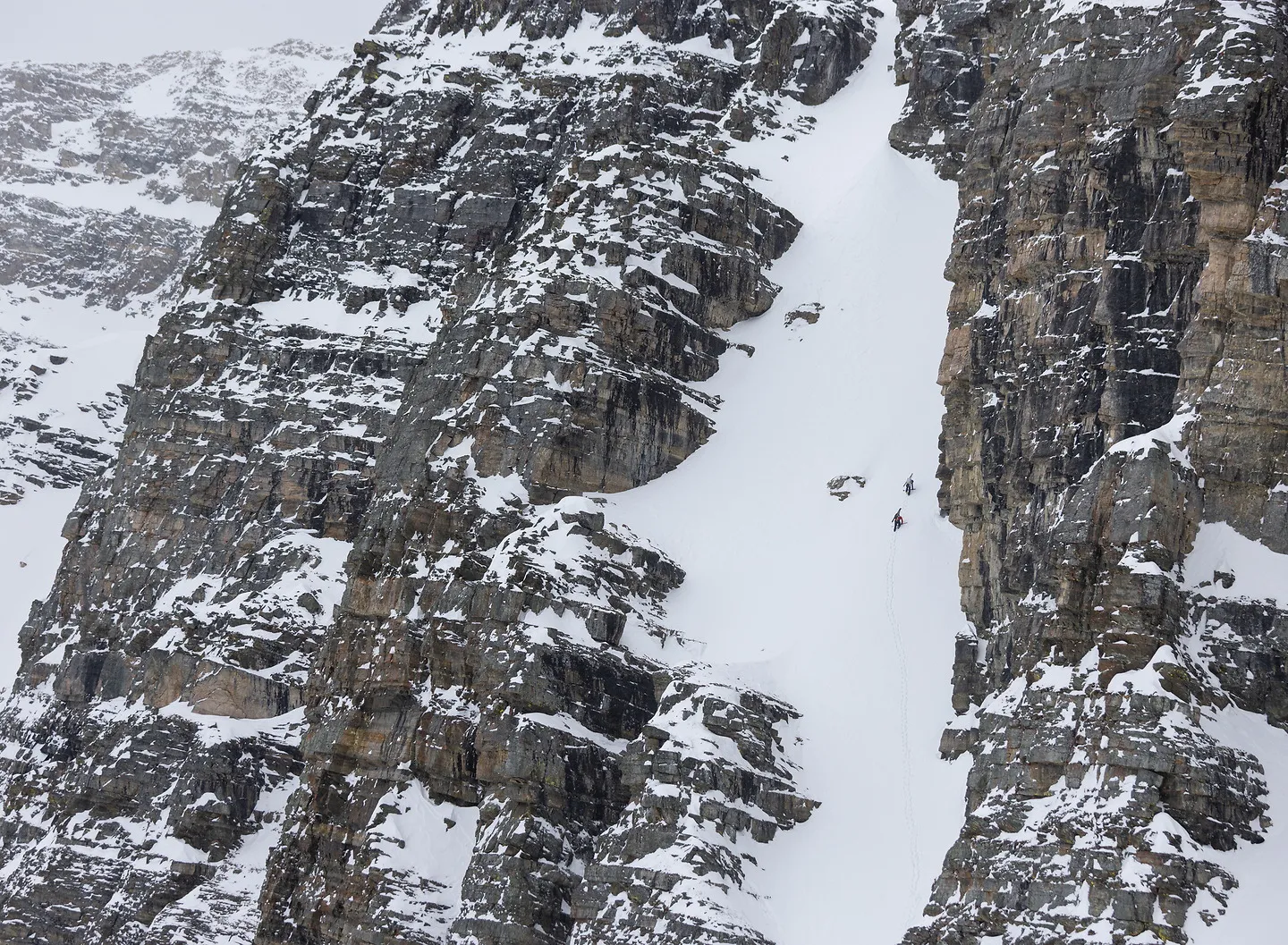 A narrow snow couloir between rock walls